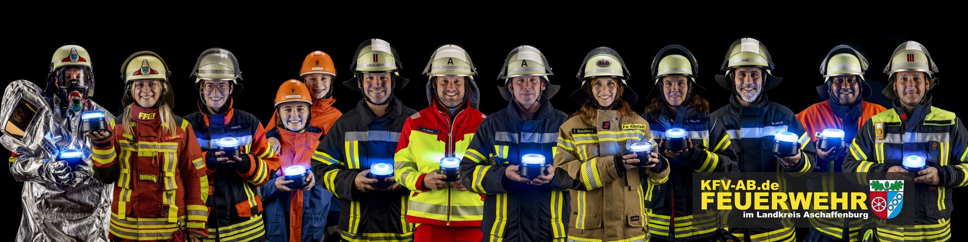 Gruppenbild von Feuerwehrleuten mit Blaulicht